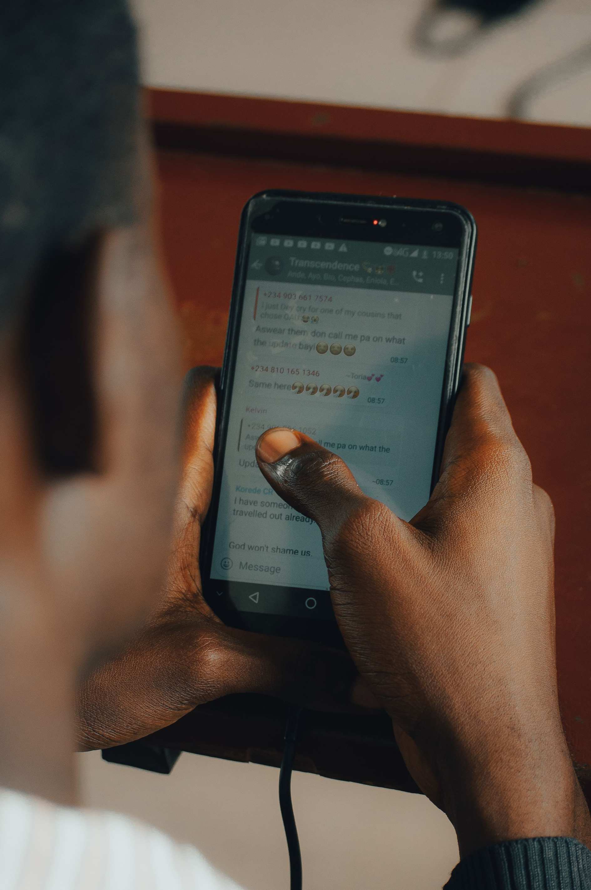 Hands holding a smartphone while working on an app indoors